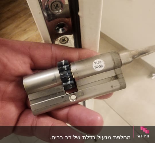 מנעול צילינדר ביד של מנעולן ליד דלת